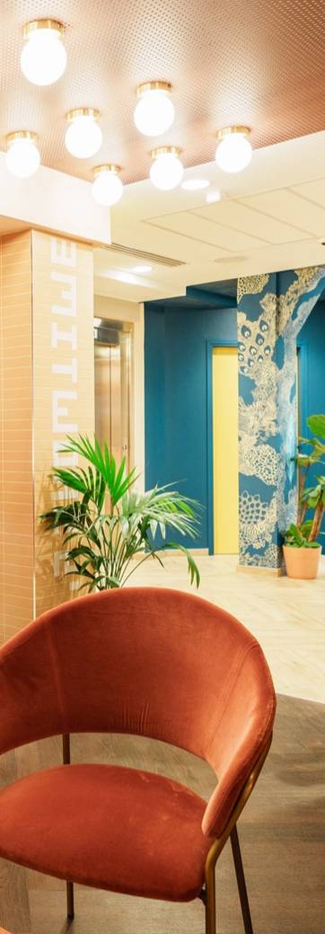 Comptoir d'accueil d'un espace de coworking, sous des arches colorées