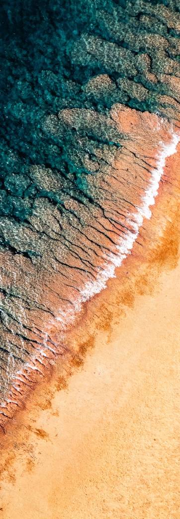 Une vague sur le sable, vue d'en haut au drone