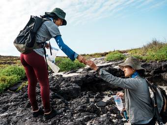 Des scientifiques s'échangent du matériel pour des relevés sur le terrain