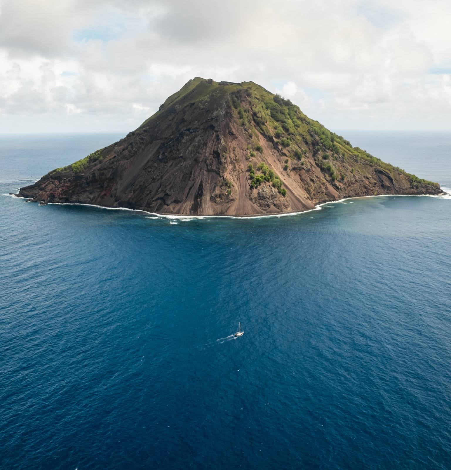 Le Captain Darwin en Polynésie française, près d'une île volcanique