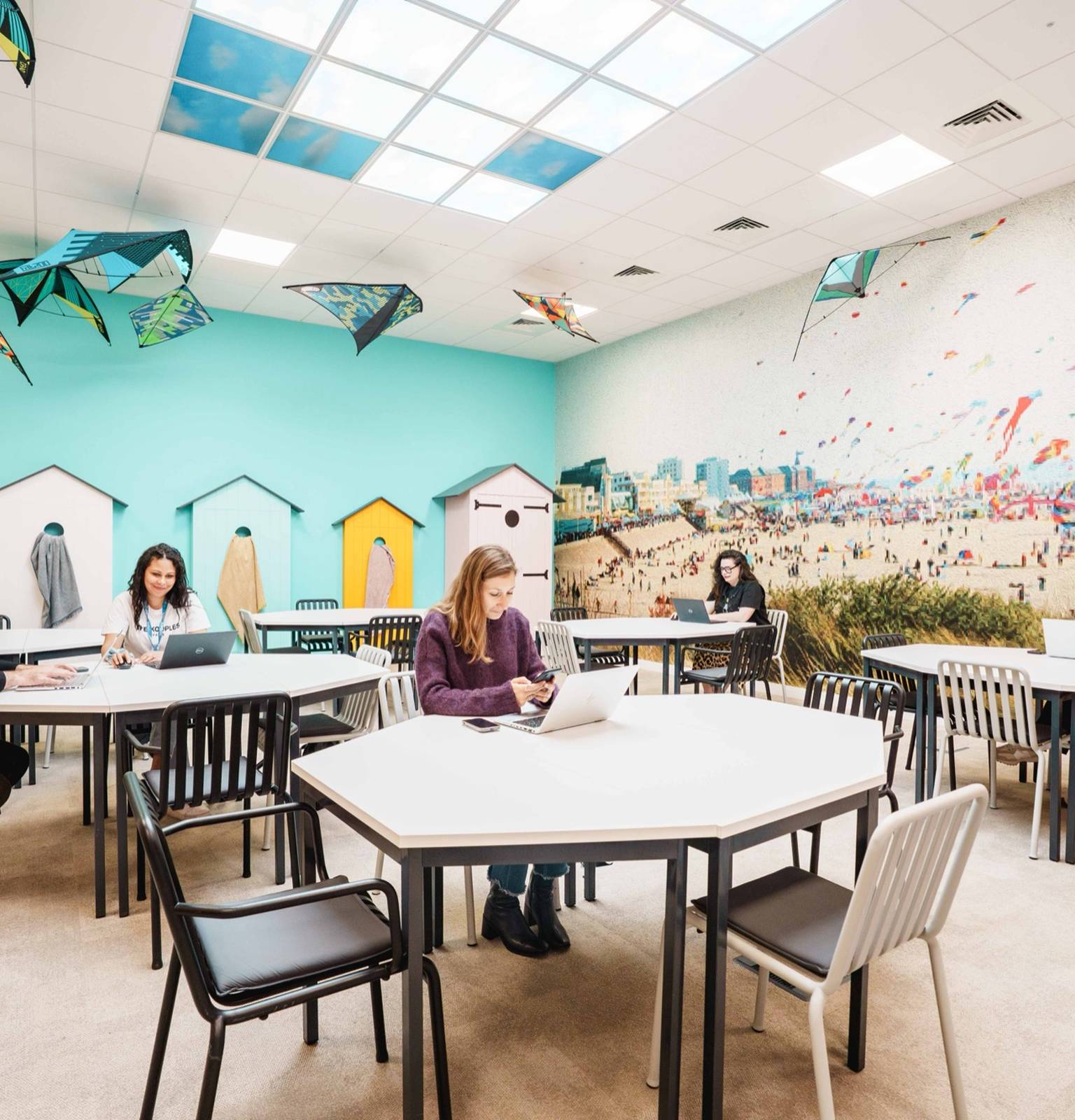 Salle de coworking décorée sur le thème de la plage, des cerfs-volants au plafond